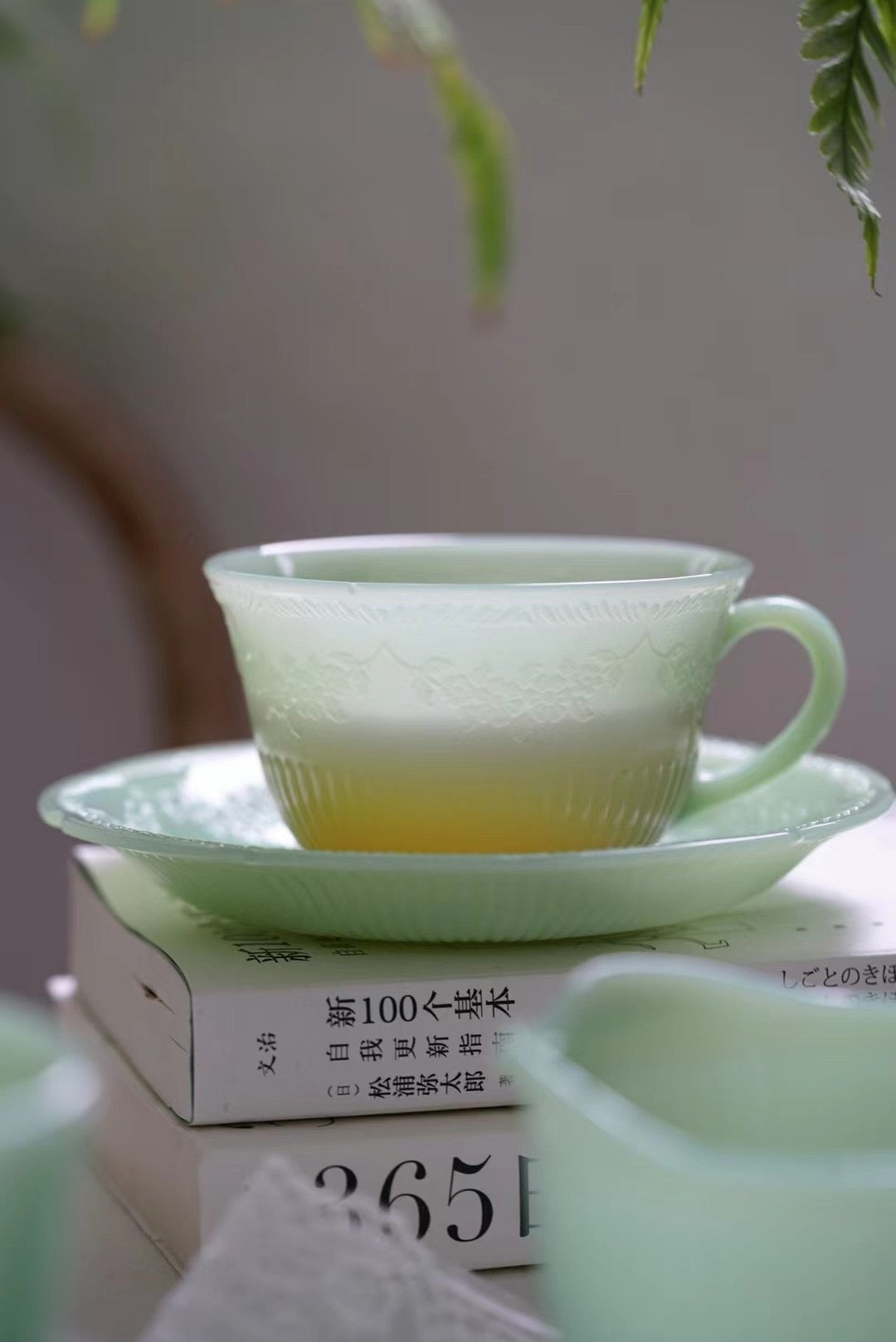 Jade green vintage cup beside books